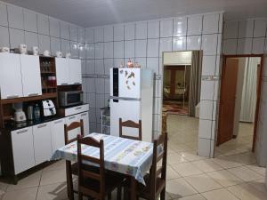 uma cozinha com uma mesa e um frigorífico branco em Casa Temporada Prado-BA em Prado