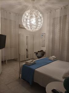 een slaapkamer met een bed en een kroonluchter bij B&B Il Siciliano in Siracusa