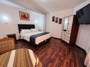 Cette chambre comprend 2 lits et une télévision. dans l'établissement FRIENDLY AQP, à Arequipa