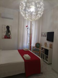 een slaapkamer met een grote kroonluchter boven een bed bij B&B Il Siciliano in Siracusa