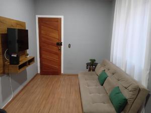 a living room with a couch and a television at Apartamento encantador in Belo Horizonte