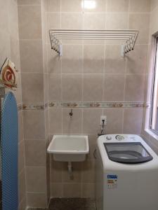 Baño pequeño con aseo y lavamanos en Apartamento encantador, en Belo Horizonte