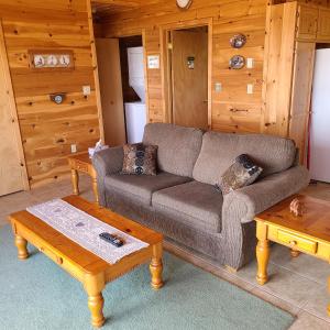 a living room with a couch and a coffee table at Sleepy Pines Oceanfront Cottages in Cumberland