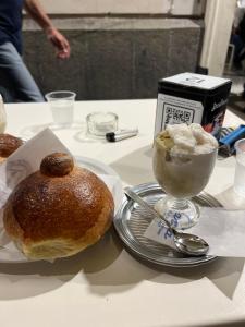 un tavolo con un piatto di pane e una ciotola di gelato di The Artists ad Acireale