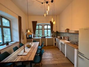 a large kitchen with a wooden table and chairs at Ferienwohnung Hortensie Rittergut Schloss Zehista Gutshaus in Pirna