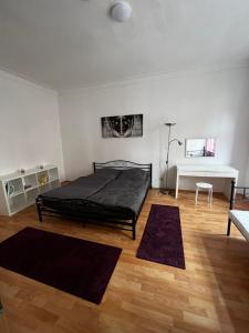 ein Schlafzimmer mit einem Bett und zwei Teppichen auf dem Boden in der Unterkunft Altstadtperle-Herz der Altstadt in Kaiserslautern