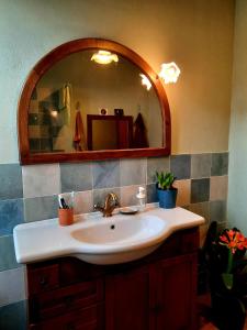 La Casa del Sole في Sassofortino: حمام مع حوض ومرآة