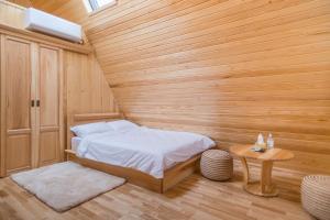 sypialnia z łóżkiem w drewnianym pokoju w obiekcie Arhico Cabins w mieście Satu Mare