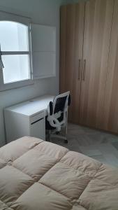 a bedroom with a bed and a desk and a chair at apartamento gaditano in Cádiz