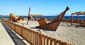 une rangée de balançoires sur une plage près de l'océan dans l'établissement Kyma Holiday Loft, à Artemi