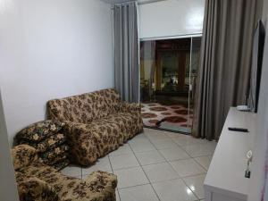 Casa Temporada Prado-BA في برادو: غرفة معيشة مع أريكة وكرسي