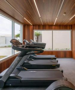 una fila de cintas de correr en un gimnasio con ventanas en Salinas Exclusive Resort en Salinópolis