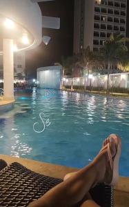 uma mulher deitada à beira de uma piscina à noite em Salinas Exclusive Resort em Salinópolis