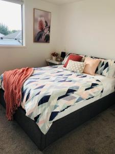a bedroom with a bed with a colorful comforter at Perfect modern Townhouse CBD Christchurch in Christchurch