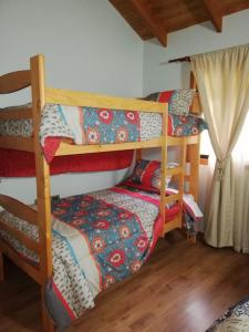 a room with three bunk beds in a house at Preciosa Casa en Parcela con chimenea 3d 2b in Villarrica