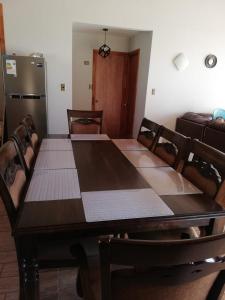 a dining room with a table and a refrigerator at Preciosa Casa en Parcela con chimenea 3d 2b in Villarrica
