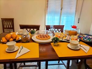 a dining room table with breakfast foods on it at B&B Rosa dei Venti in Sorso
