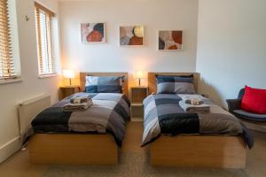 dos camas sentadas una al lado de la otra en un dormitorio en Hawkesmoor House, en Londres