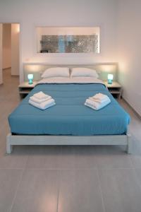 Elle comprend un grand lit avec des draps et des oreillers bleus. dans l'établissement Rocciola Home, à Salerne