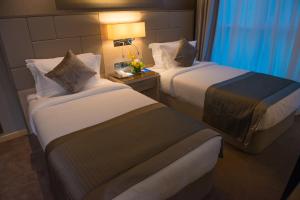 a hotel room with two beds and a lamp at TRYP by Wyndham Abu Dhabi City Center in Abu Dhabi