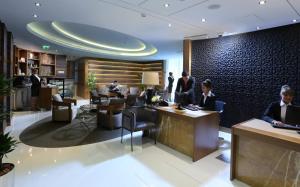 a lobby with people working at desks in a hotel at TRYP by Wyndham Abu Dhabi City Center in Abu Dhabi