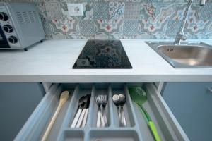 - un comptoir de cuisine avec des ustensiles dans un tiroir sous un évier dans l'établissement Rocciola Home, à Salerne