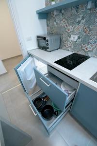 - une cuisine avec une armoire ouverte et une cuisinière dans l'établissement Rocciola Home, à Salerne