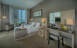 a large hotel room with a bed and a desk at TRYP by Wyndham Abu Dhabi City Center in Abu Dhabi