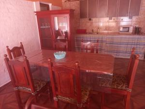 a kitchen with a wooden table with chairs and a counter at CASA PARA ALQUILER LA LILI in Uspallata