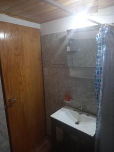 a bathroom with a sink and a wooden door at CASA PARA ALQUILER LA LILI in Uspallata