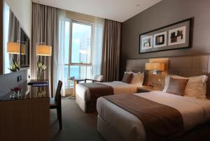 a hotel room with two beds and a window at TRYP by Wyndham Abu Dhabi City Center in Abu Dhabi