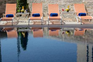 a group of chairs sitting next to a pool of water at TRYP by Wyndham Abu Dhabi City Center in Abu Dhabi
