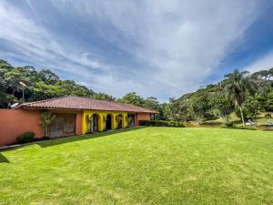 a house with a large lawn in front of it at Hotel Fazenda Filhos do Vento in Cachoeiras de Macacu