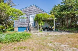 a house with a porch and stairs to a yard at 34 North Shore Boulevard Extension East Sandwich - - Cape Cod in East Sandwich