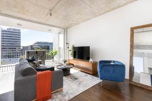 a living room with a couch and a tv at The Chromatic Apartments by Urban Rest in Sydney