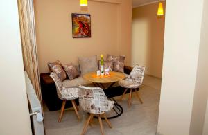 - un salon avec un canapé, une table et des chaises dans l'établissement Stadium Apartments, à Veliko Tarnovo