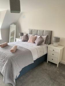 1 dormitorio con 1 cama grande con almohadas rosas en Foxborough BnB, en Droichead an Chaisleáin