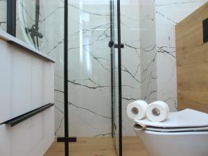 e bagno con servizi igienici e doccia in vetro. di Apartment Talarowa Delux a Varsavia