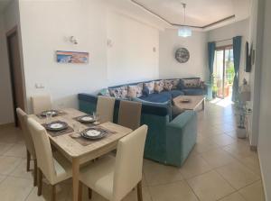 a living room with a blue couch and a table at BERALMAR CHEZ HOUDA VACANCES PIEDS DANS l' EAU in Asilah