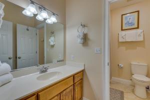 a bathroom with a sink and a toilet and a mirror at 1 Mi to Beach Access Spacious Orange Beach Duplex in Orange Beach +27 photos
