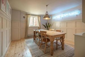 a dining room with a wooden table and chairs at Stylish Seaside home with King beds and parking in Scarborough