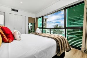 a bedroom with a white bed and a large window at Glamorous Getaway - Heart of the Viaduct 'Quays' in Auckland