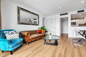 a living room with a couch and a table at Glamorous Getaway - Heart of the Viaduct 'Quays' in Auckland