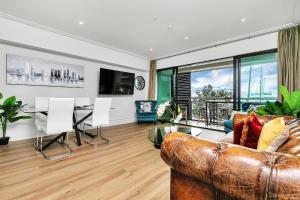 uma sala de estar com um sofá e uma mesa em Glamorous Getaway - Heart of the Viaduct 'Quays' em Auckland