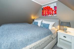 1 dormitorio con 1 cama y una pintura en la pared en Maritim und individuell in Wenningstedt mit Balkon, en Wenningstedt