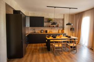 Il comprend une cuisine équipée d'une table et d'un réfrigérateur noir. dans l'établissement Lepanto Xenia Apartments 3F, à Naupacte