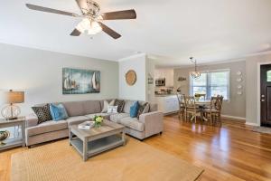 a living room with a couch and a ceiling fan at Modern Southern Comforts Home Near Charleston in Charleston