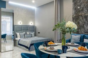 ein Hotelzimmer mit einem Bett und einem Tisch mit Essen in der Unterkunft Family Residence Boutique Apartments in Lwiw