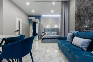 ein Wohnzimmer mit einem blauen Sofa und einem Bett in der Unterkunft Family Residence Boutique Apartments in Lwiw
