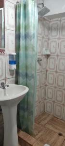 a bathroom with a sink and a shower curtain at Casa D´Maria in Ollantaytambo